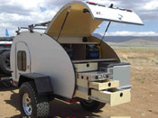 1991 Ford Bronco - This teardrop trailer features a fully equipped outdoor kitchen with a pull-out stove and storage drawers.