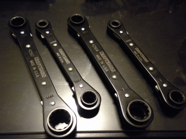 Four black Craftsman ratcheting box-end wrenches laid in a row
