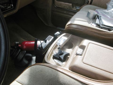 1986 Ford Bronco - Car interior with a nitrous bottle and radio installed in the center console area.