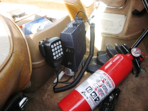 1986 Ford Bronco - Interior view of a vehicle showing a Kenwood radio, microphone, and a red fire extinguisher.