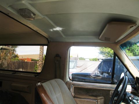 1986 Ford Bronco - View from inside an older vehicle, showing the interior and a glimpse of the exterior.
