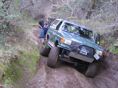 1989 Ford Bronco - Modified 1989 Ford Bronco tackling a challenging muddy off-road course.