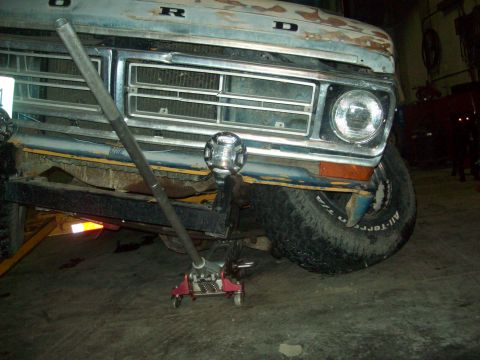1971 Ford F-100 - Front view of a 1971 Ford F-100 being worked on with a floor jack.