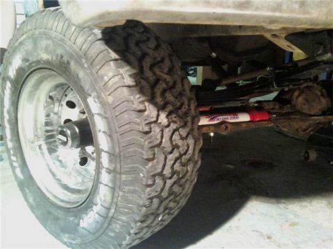 1971 Ford F-100 - Detail shot of truck suspension components, including a tire, wheel, and shock absorber.