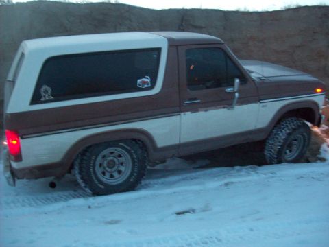 1985 Ford Bronco - This two-tone brown and white 1985 Ford Bronco is seen driving in a snowy environment.
