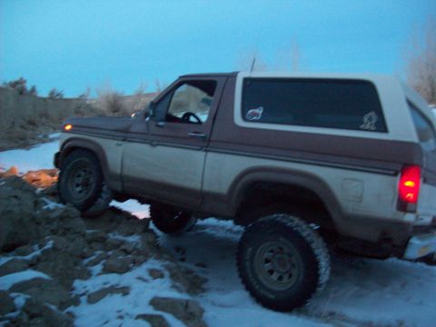 1985 Ford Bronco - This 1985 Ford Bronco is navigating a snowy, uneven terrain.