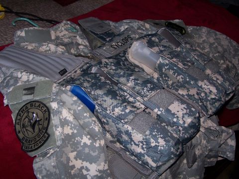 1986 Ford Bronco - A close-up view of a digital camouflage tactical vest with various pouches and patches.