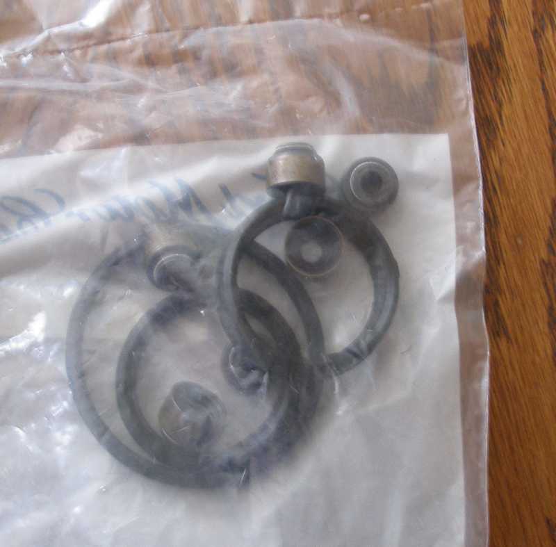 Rubber seals and metal components inside clear plastic packaging on a wooden surface