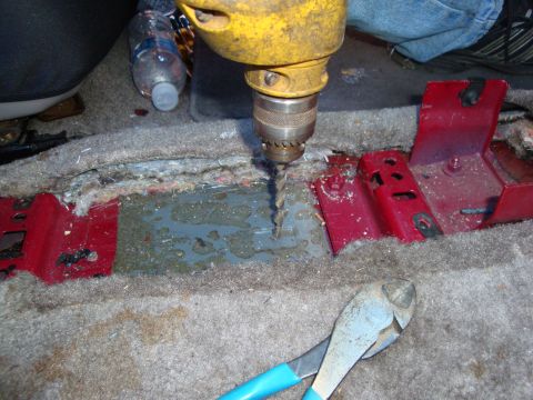 1993 Ford Taurus - Drilling into the car's interior floor reveals exposed metal and water accumulation.