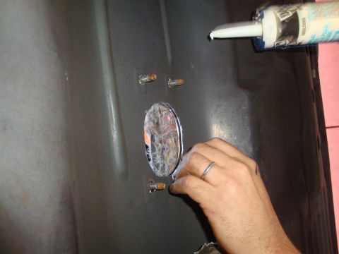 1993 Ford Taurus - Sealing an opening on a vehicle part with sealant from a caulk gun.