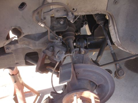 1992 Ford Taurus - Close-up view of the front suspension system, showing the brake rotor, CV axle, and various linkage components.
