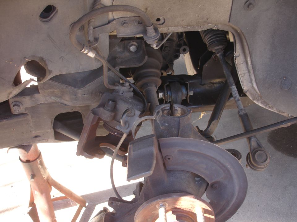 Front suspension components on a vehicle, including brake rotor and CV axle