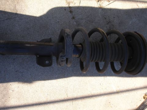 1992 Ford Taurus - A single car suspension strut assembly is shown, with its coil spring compressed.
