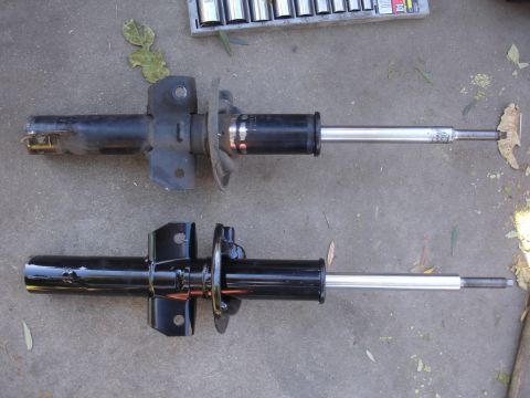 1992 Ford Taurus - Comparison of a used suspension strut with a newly painted strut, likely for replacement.
