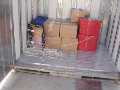 1992 Ford Taurus - The inside of a cargo area is packed with moving supplies, including boxes and red storage bins.