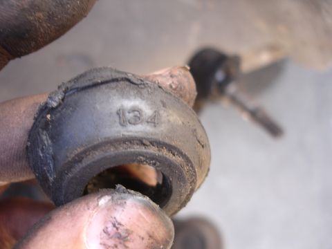 1992 Ford Taurus - A worn suspension bushing with visible cracking and the number 134 imprinted on its surface.