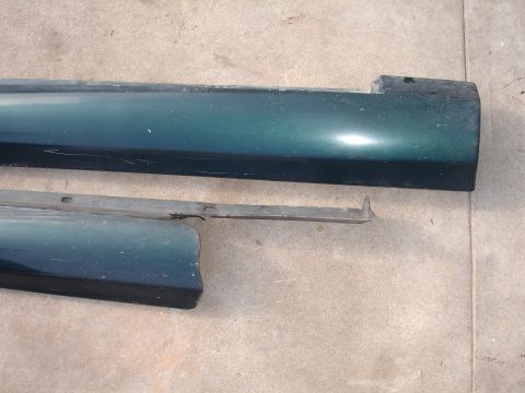 1995 Ford Taurus - Two detached car door trim pieces are shown, one above the other, on a concrete surface.