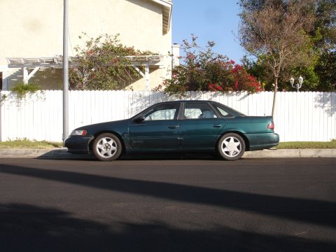 1995 Ford Taurus - Green 1995 Ford Taurus parked on a residential street.