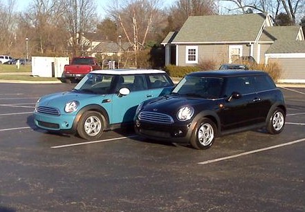 2003 Ford Crown Victoria - Two Mini Coopers are parked side-by-side in an outdoor lot.