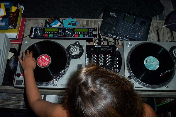 DJ setup with turntables, mixer, and Yamaha sampler
