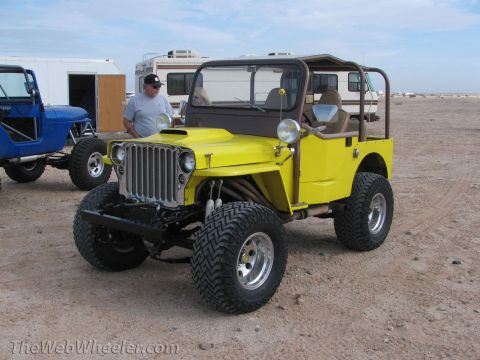 1996 Ford C-350 (Centurion Conversions) - Modified Jeep CJ-5 with custom front end and roll cage sits in a desert lot next to another Jeep.