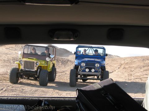 1996 Ford C-350 (Centurion Conversions) - Two Jeeps are seen off-roading in a desert environment, viewed from the interior of another vehicle.