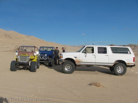 1996 Ford C-350 (Centurion Conversions) - A white extended cab pickup truck is parked in the desert alongside two Jeeps.