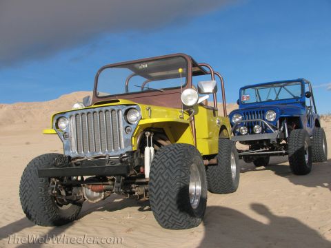 1996 Ford C-350 (Centurion Conversions) - Two custom Jeeps are parked in a sandy desert area under a cloudy sky.
