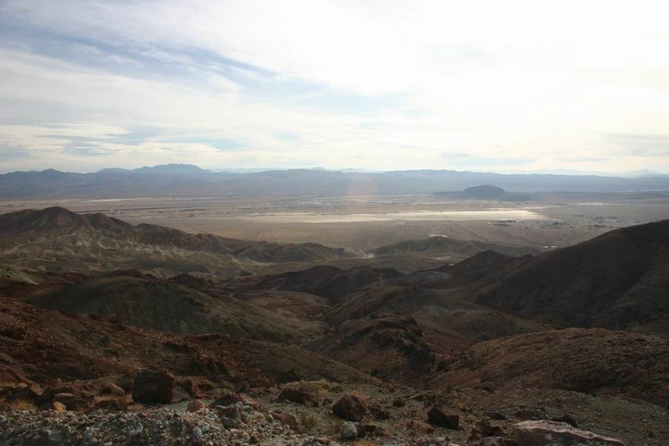 Desert mountains and valley under a cloudy sky. Supermotors.net logo in lower right