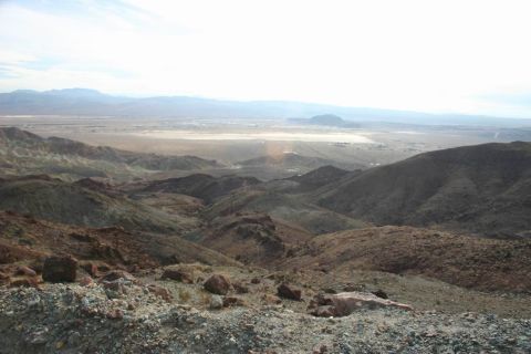 1991 Ford Bronco - A vast desert valley stretches out below , rocky hills under a hazy sky.
