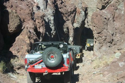 1991 Ford Bronco - Multiple off-road vehicles navigate a narrow canyon path.