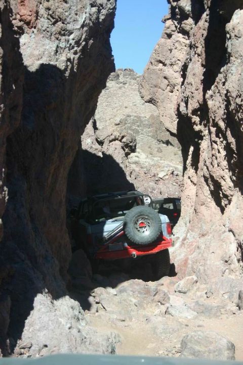 1991 Ford Bronco - Off-road vehicles are stuck in a narrow passage between large rock formations.