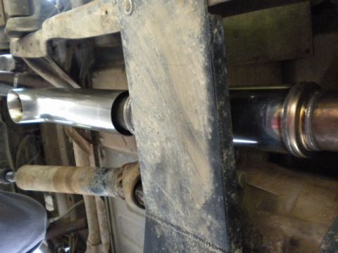 1989 Ford Bronco - Underside view of a vehicle's exhaust system and driveshaft, showing a new pipe.