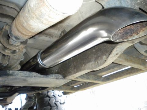 1989 Ford Bronco - Close-up view of the undercarriage, focusing on the exhaust system and drivetrain components.