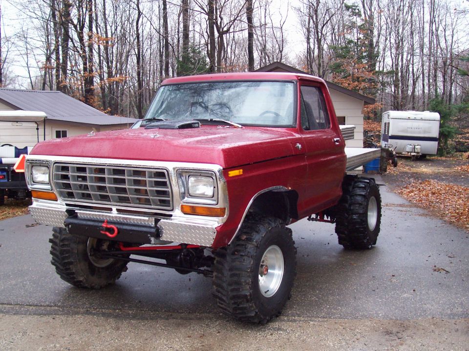 Red 1978 Ford F-150 with large tires and flatbed
