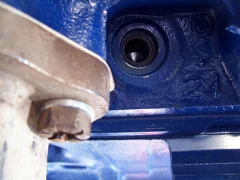 1978 Ford F-150 - A close-up view of a blue engine block shows a bolt and a recessed opening, with cast numbers '24' visible.
