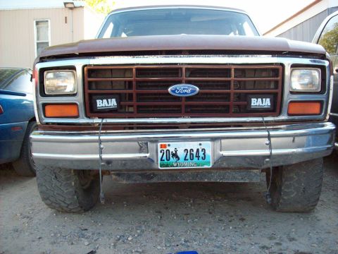 1985 Ford Bronco - Front view of a brown Ford Bronco with a prominent grille and license plate.