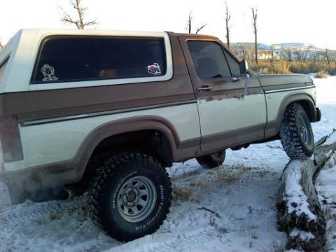 1985 Ford Bronco - This 1985 Ford Bronco is navigating an obstacle in a snowy environment.