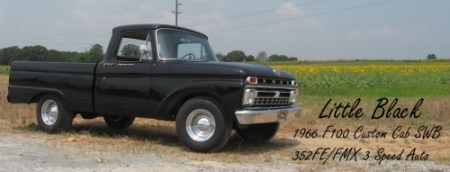 1966 Ford F-100 - A black 1966 Ford F-100 pickup truck is shown parked outdoors with a field of sunflowers in the background.