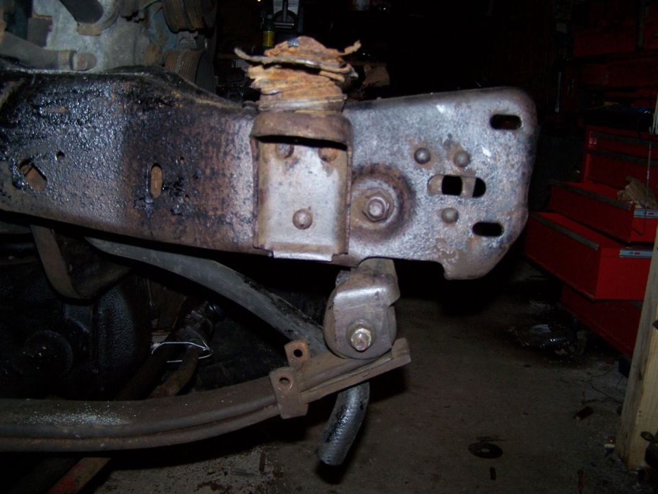 Rusted truck frame section with leaf spring and shock mount