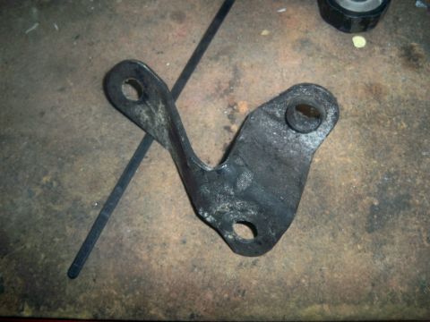 1985 Ford Bronco - A single metal bracket, likely a vehicle part, is shown against a textured surface.