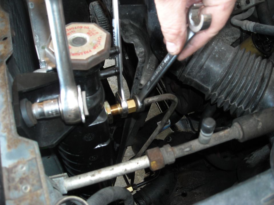 a 1/2 inch line wrench and a 5/8 open end is used to take off the transmission lines.
USE A LINE WRENCH.
trying to cheap out here will probably round off the radiator nut.
Hold the larger nut with the 5/8 and loosen the 1/2 inch one so it spins.
Then, loosen up the 5/8 all the way out of the radiator. Keep an eye on the line and make sure that 1/2 is spinning with the 5/8 so you don't kink the line.