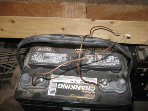 2004 Aston Martin Virage - A car battery is shown with wires attached to its terminals, leading to a small LED light.