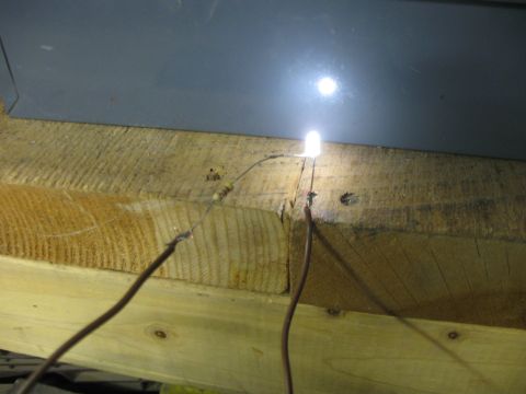 2004 Aston Martin Virage - An LED light is powered by wires connected to a resistor, mounted on wooden beams.