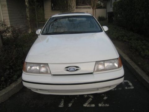 1993 Ford Taurus - Front view of a white 1993 Ford Taurus parked in a lot.
