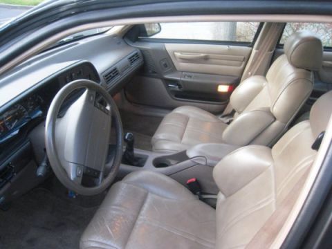 1993 Ford Taurus - The tan leather interior of a 1993 Ford Taurus features bucket seats and a center console.