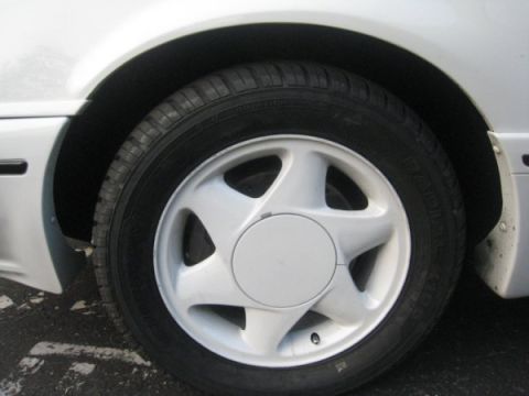 1993 Ford Taurus - Close-up of a white five-spoke wheel on a 1993 Ford Taurus.