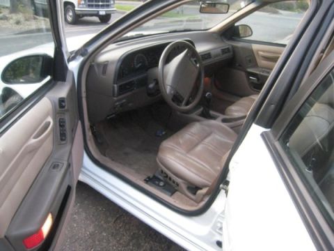 1993 Ford Taurus - The interior of a car is shown, with a view of the driver's seat and dashboard. Another vehicle is visible through the window.