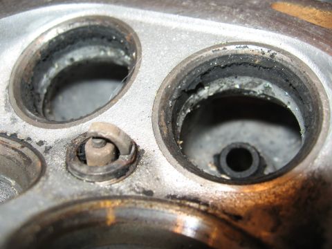 1991 Mitsubishi 3000GT - Engine cylinder head with carbon buildup around the spark plug and valve seats.