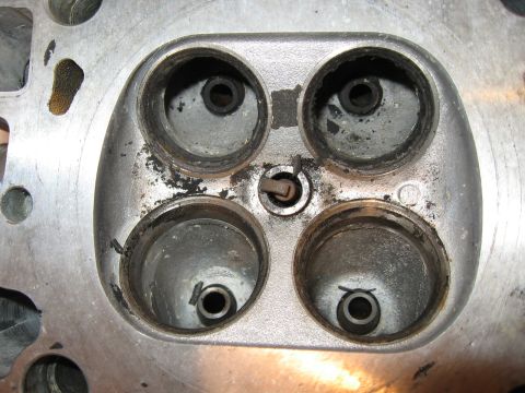 1991 Mitsubishi 3000GT - Engine cylinder head showing four valve ports with visible carbon deposits.